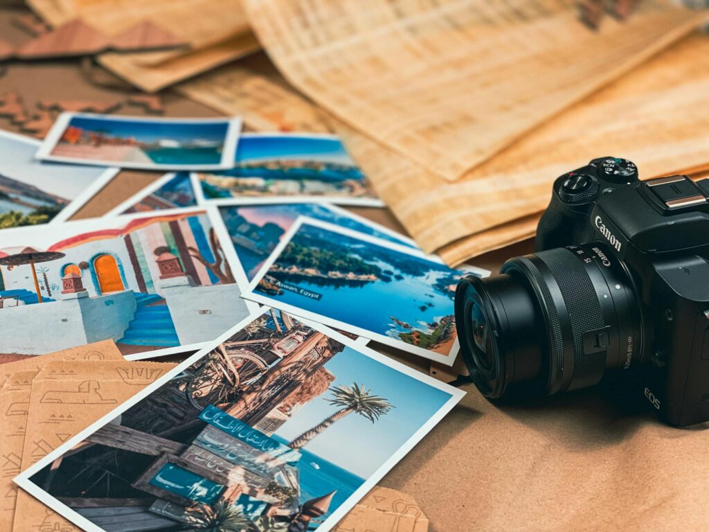 A collection of travel photos alongside a Canon camera, symbolizing adventure and creativity.